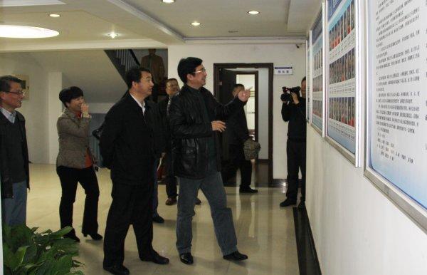 邹文辉、王建华一行饶有兴致地观看新一届领导班子成员及全馆员工一览表