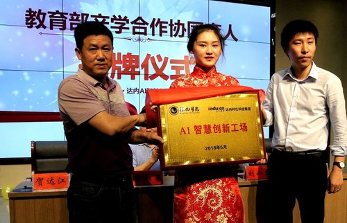 教务处处长贺达江（左）与达内时代科技集团湖南基地中心主任沈毅共同为
